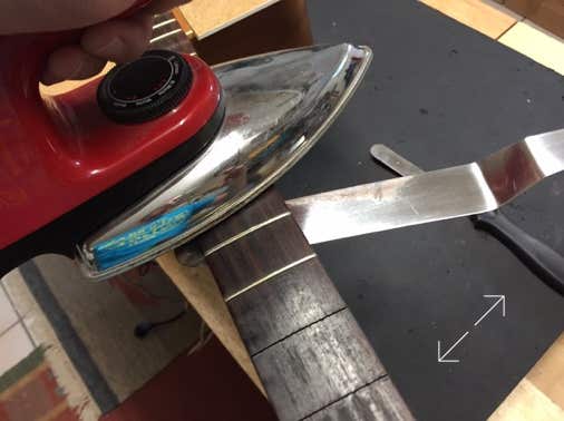 Das Griffbrett wird mit einem Bügeleisen erwärmt.